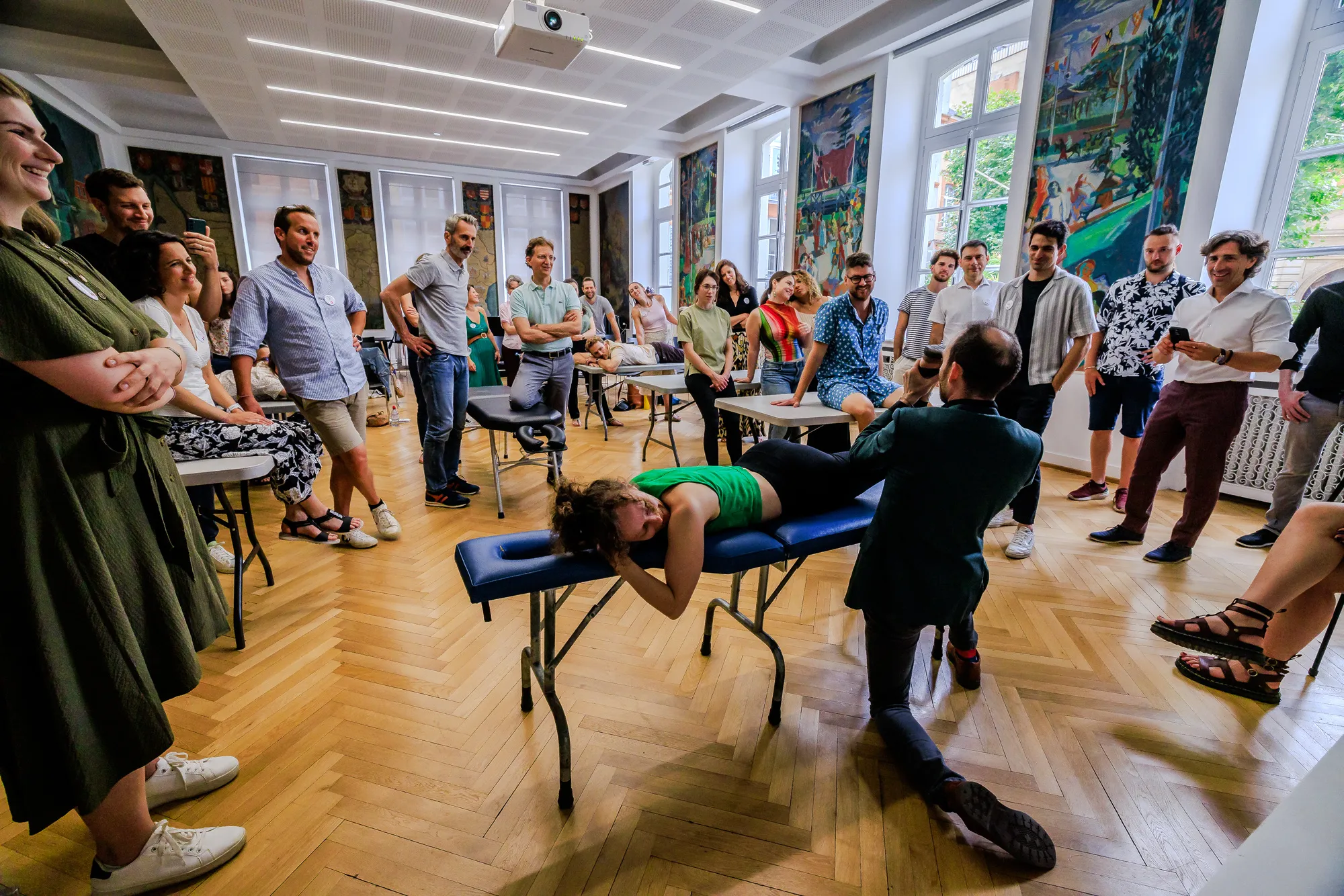 Practitioners from many countries gathered around a treatment table during an ICAK seminar