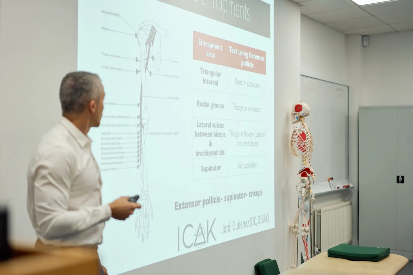 An ICAK instructor teaching from an anatomy slide during a chapter seminar